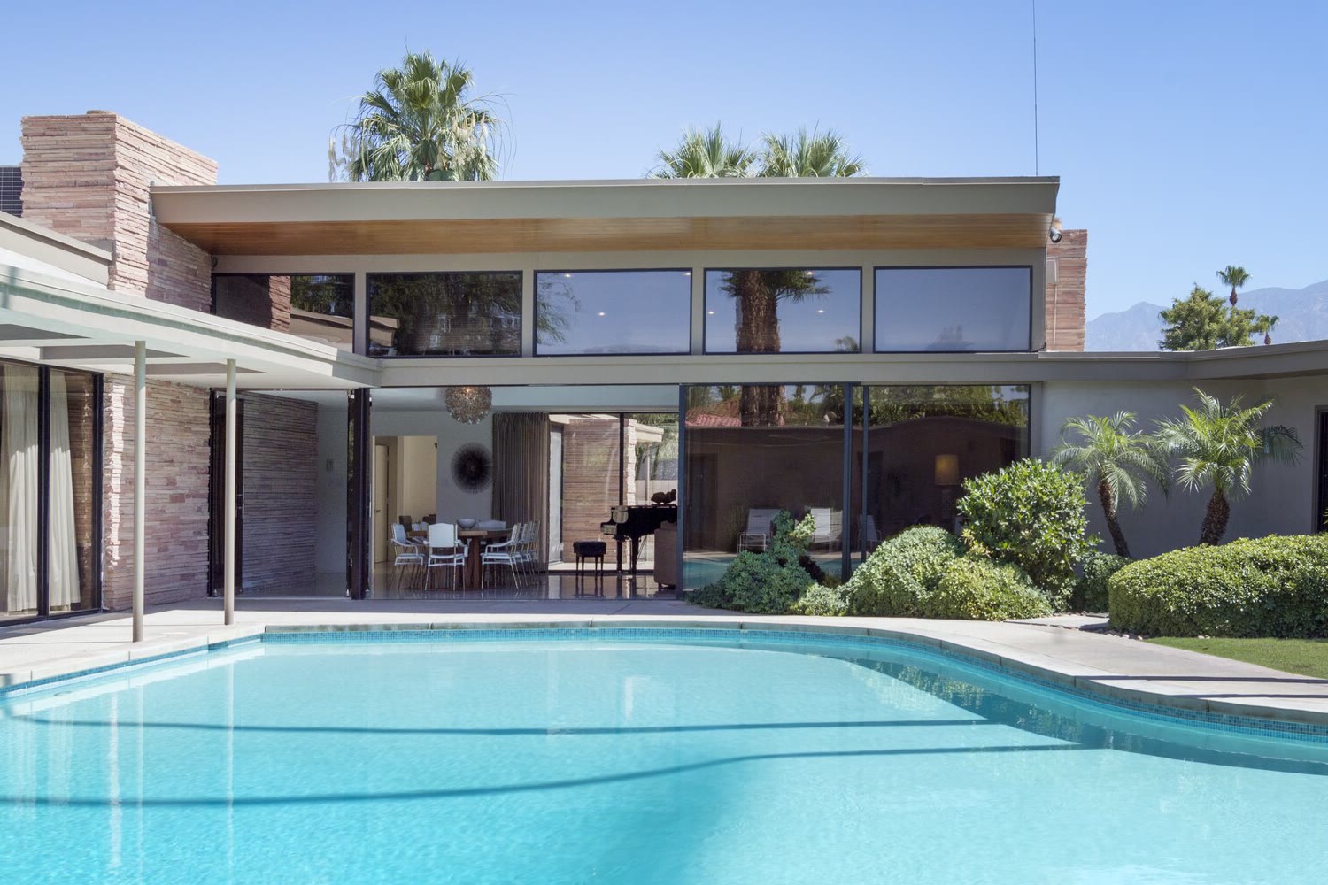 Inspiration photo: a mid-century house with a glass living room and clerestory windows opening onto a pool terrace