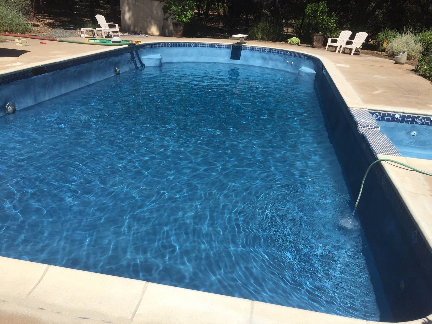 Long rectangular pool with deep blue finish and an attached spa